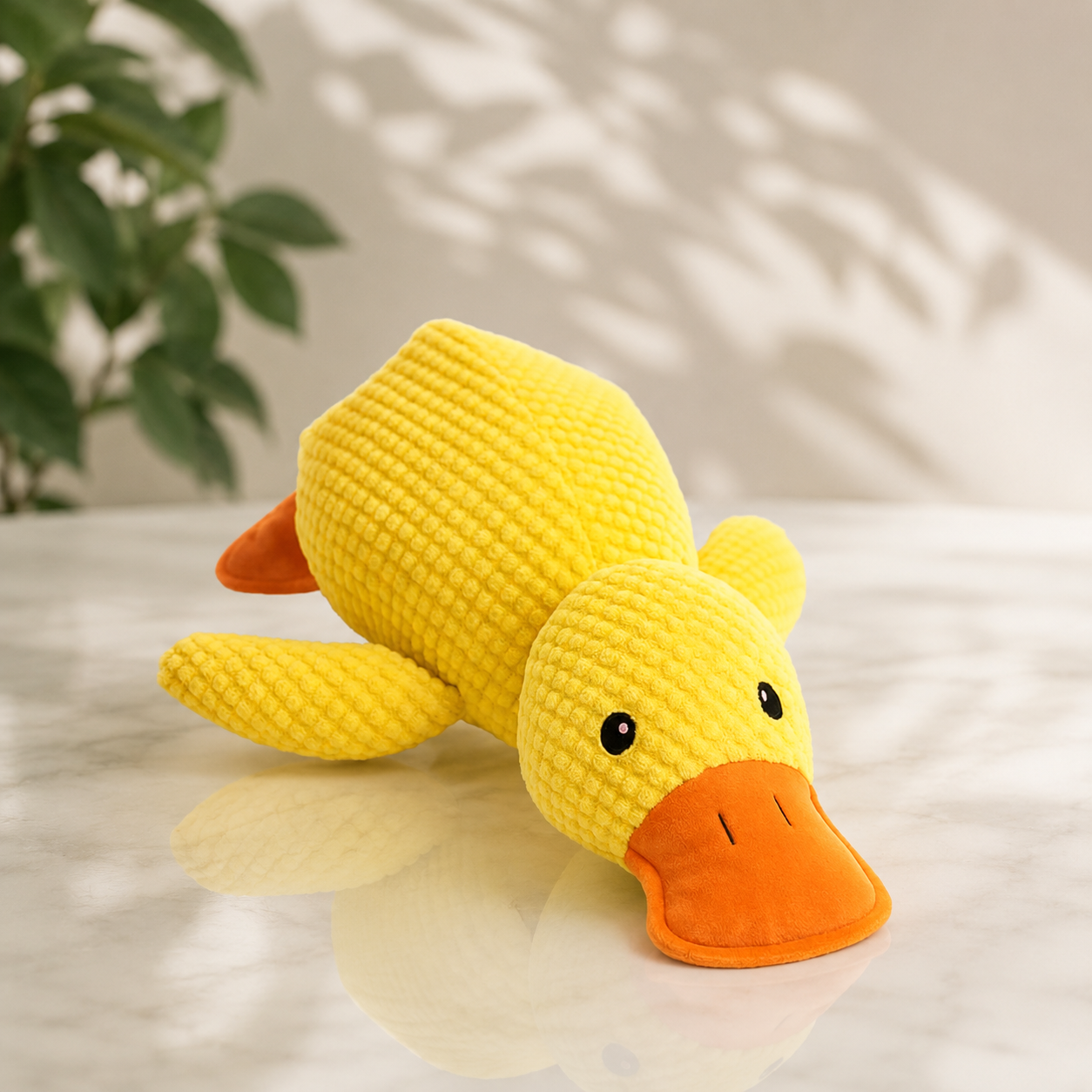CalmiDuck pluche antistress eend geel op marmeren ondergrond