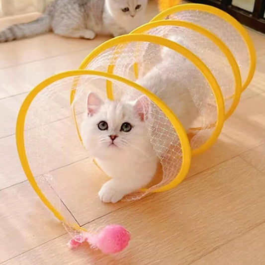 SpiralChase kattentunnel geel — wit katje zit in de uitgevouwen speeltunnel met roze balletje ervoor